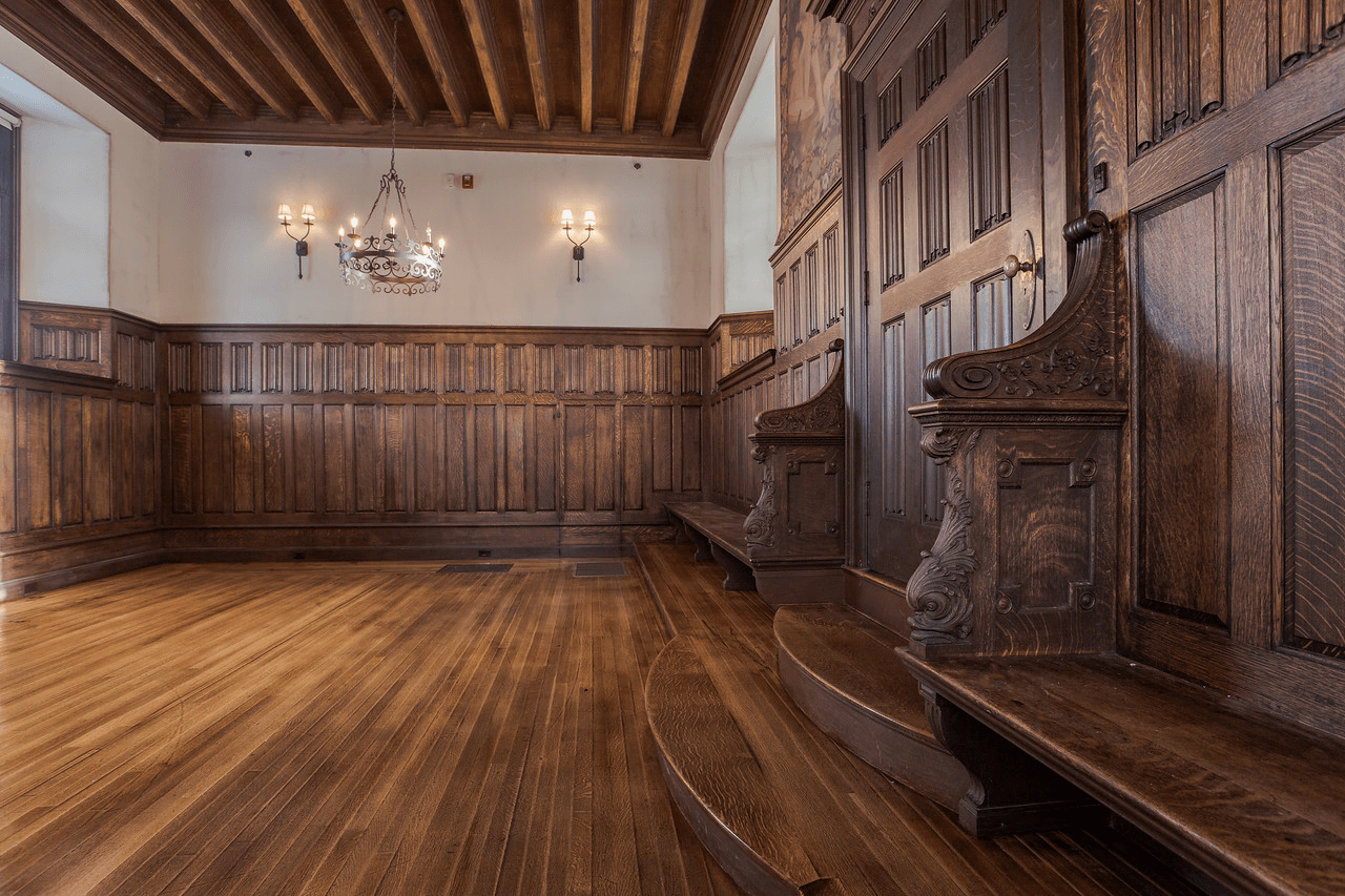 Interior view of a wood paneled and wood floored historical looking room.